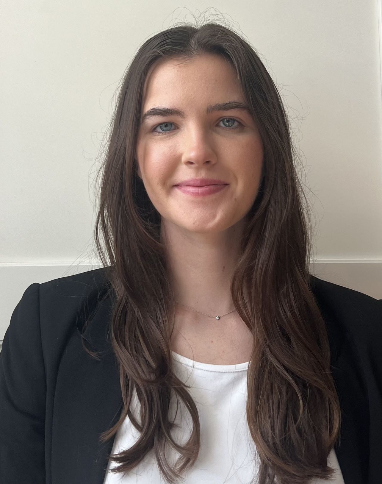 Portrait of Americorps Fellow Caroline Sharis wearing a dark suit and white shirt