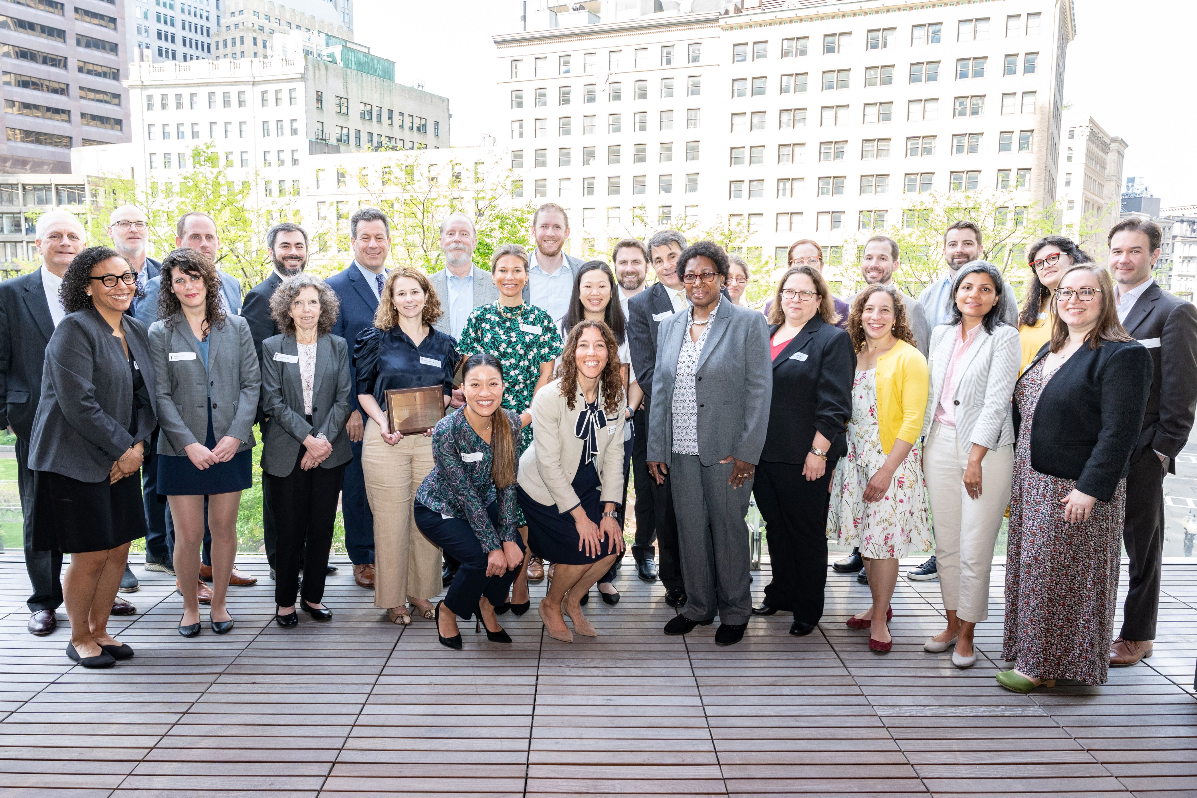 Attendees of the GBLS' Legal Community Thank You event pose on a balcony overlooking Post Office Square