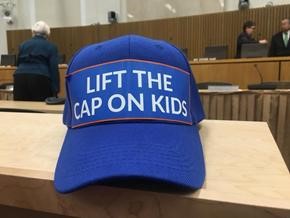Blue baseball cap with the phrase "Lift the Cap on Kids" emblazoned on the front.