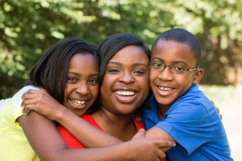 Client "Fiona" smiling with two of her children