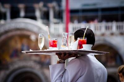A waiter carries a tray of drinks.